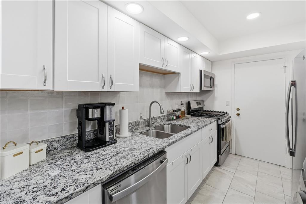 6851 Roswell Road, Unit H29 Atlanta, GA 30328 - Photo 10 of 50 a kitchen with stainless steel appliances granite countertop a sink stove and refrigerator