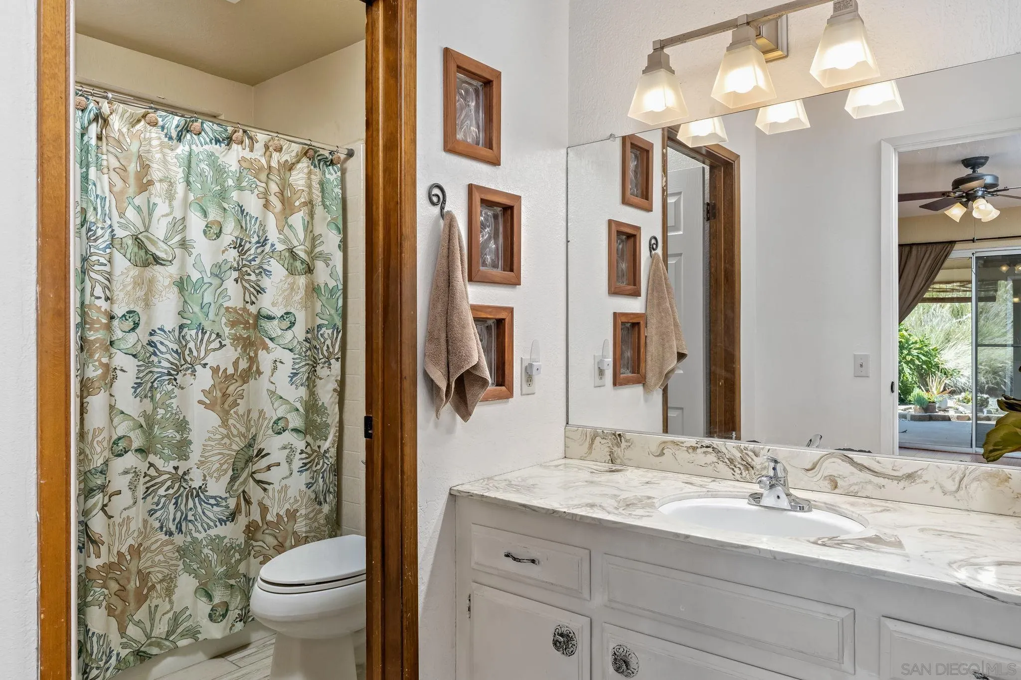 244 Avalon Drive Vista, CA 92084 - Photo 11 of 23 a bathroom with a granite countertop sink a toilet and a large mirror