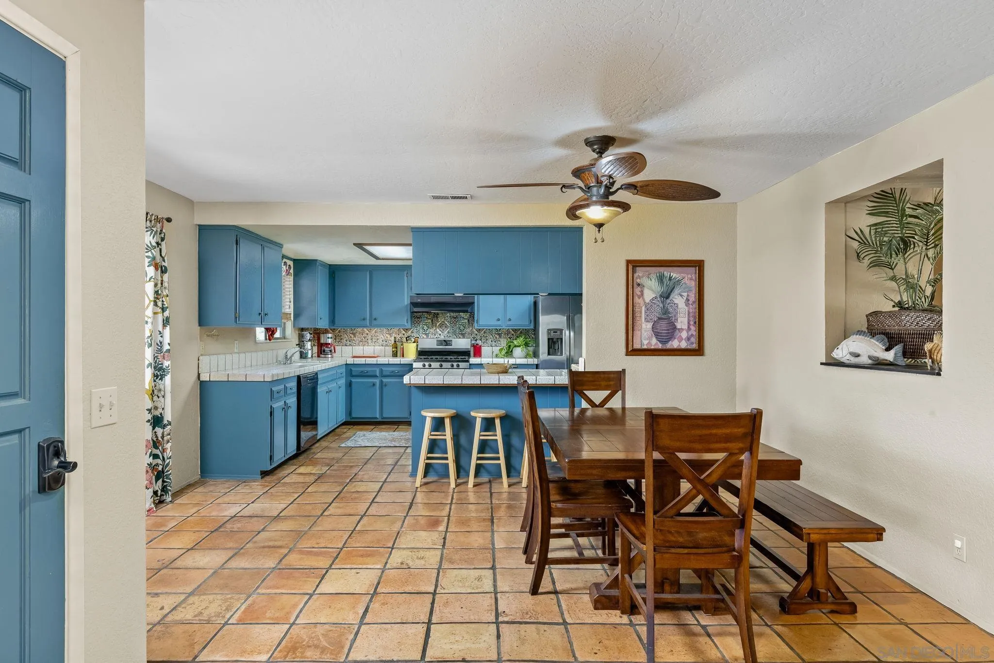 244 Avalon Drive Vista, CA 92084 - Photo 6 of 23 a kitchen with stainless steel appliances kitchen island granite countertop a dining table chairs and a refrigerator