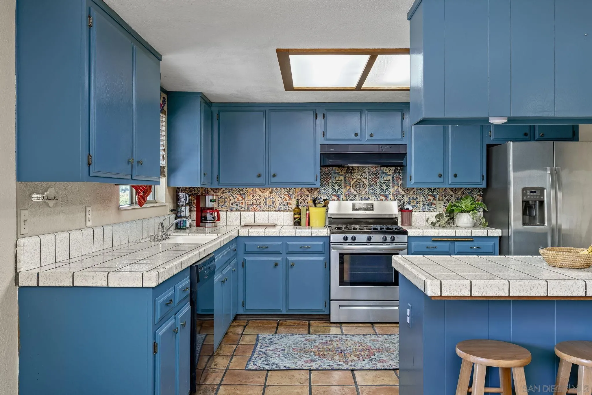 244 Avalon Drive Vista, CA 92084 - Photo 7 of 23 a kitchen with stainless steel appliances granite countertop wooden cabinets a stove top oven a sink and dishwasher