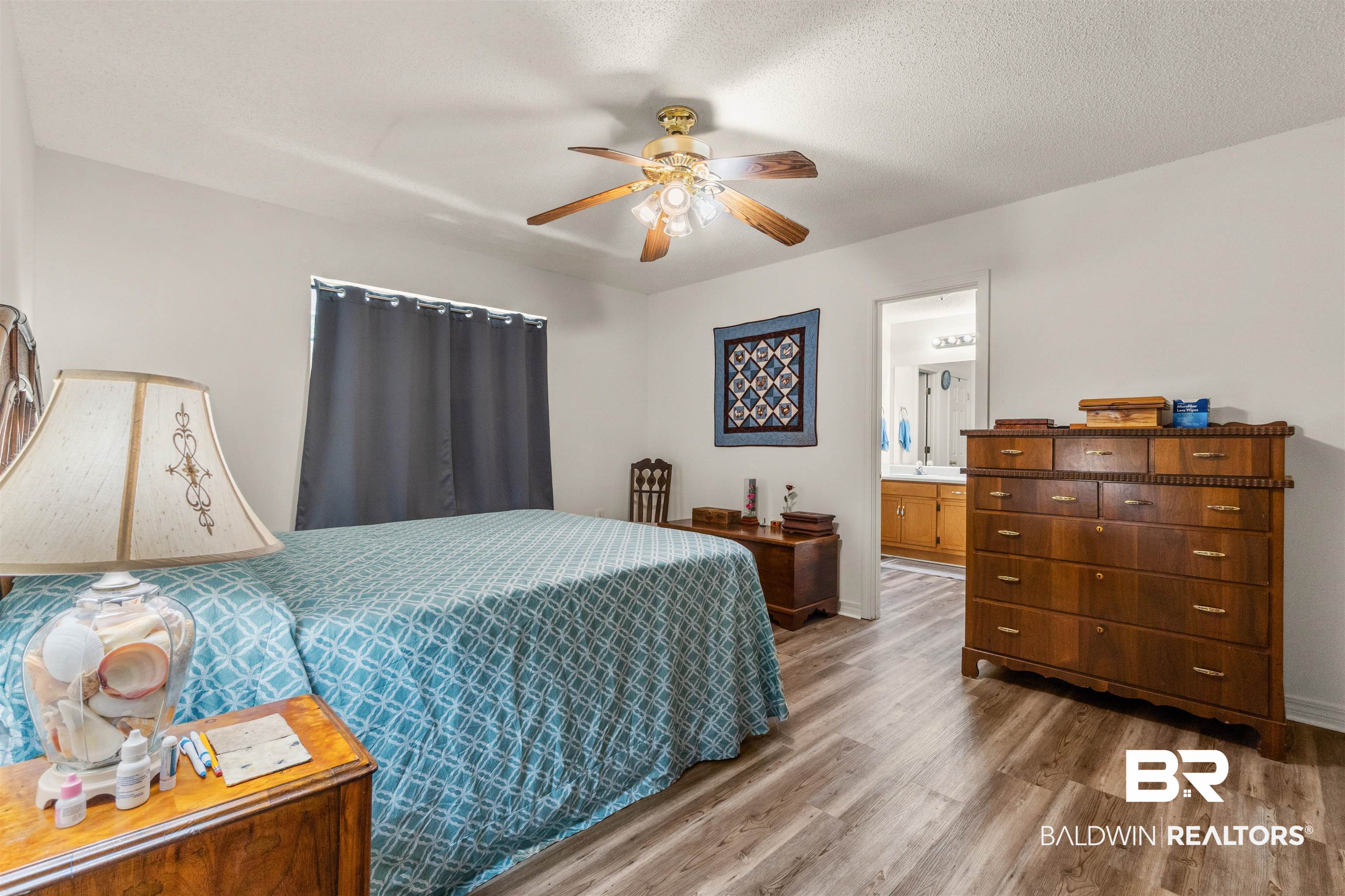 35893 Pine Road South Stapleton, AL 36578 - Photo 15 of 31 Spacious room featuring wood-finish flooring, a ceiling fan with integrated lighting, and a window with dark privacy curtains