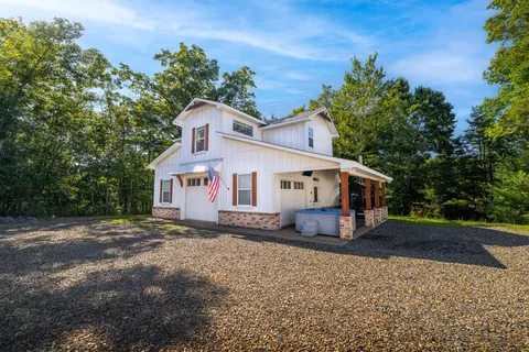 a view of a patio with a table and chairs under an umbrella