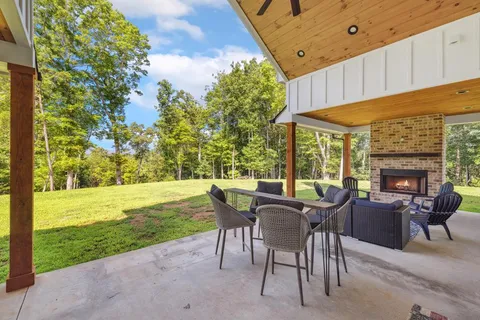 a kitchen with stainless steel appliances kitchen island granite countertop a table chairs and a wooden floor