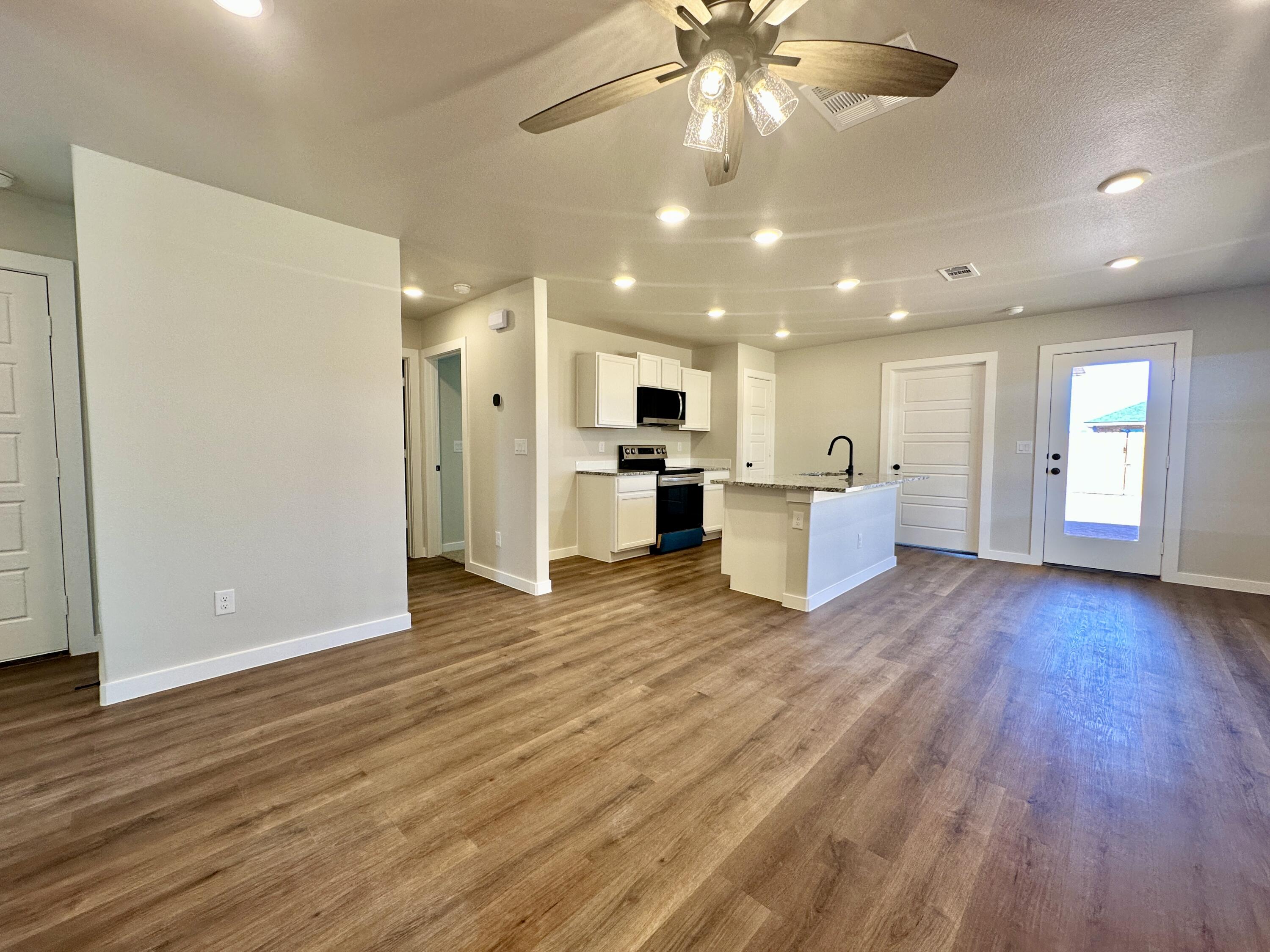 5528 Princeton Street Lubbock, TX 79416 - Photo 2 of 10 a view of a big room with wooden floor and a kitchen