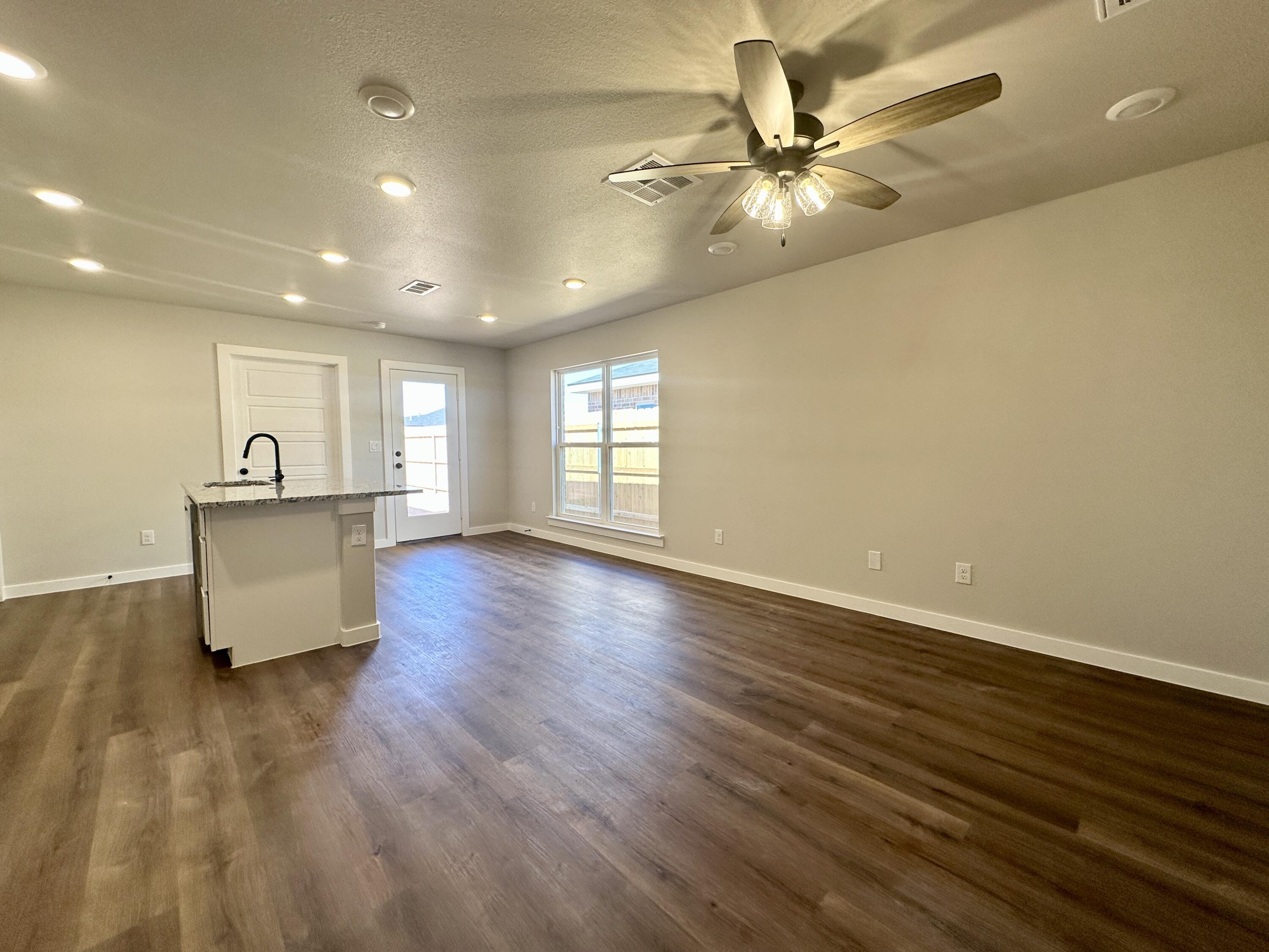 5528 Princeton Street Lubbock, TX 79416 - Photo 4 of 10 a view of an empty room with window and wooden floor