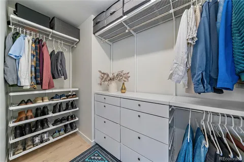 a view of walk in closet with clothes and shoes