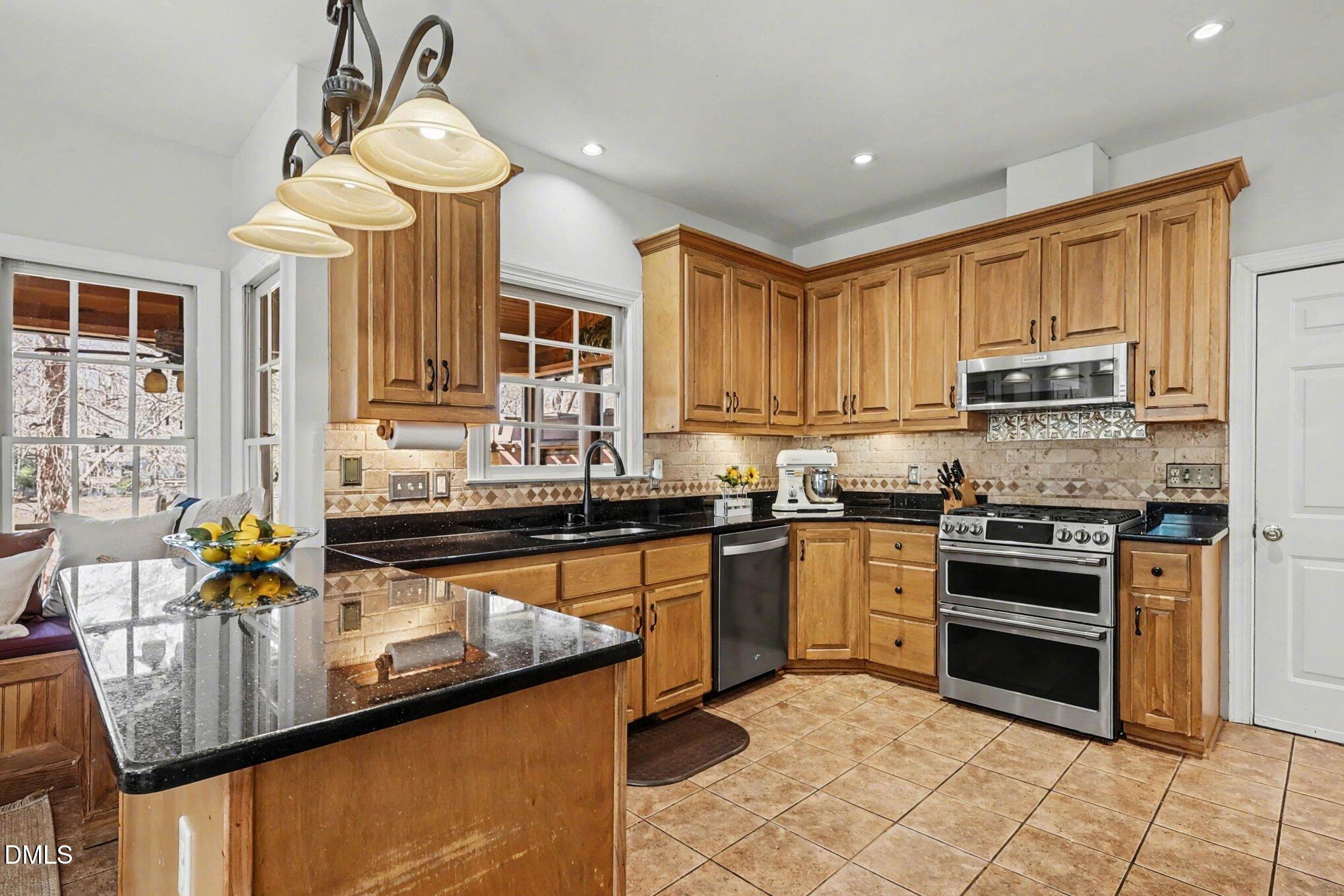 119 Felspar Way Cary, NC 27518 - Photo 13 of 53 a kitchen with stainless steel appliances granite countertop a stove refrigerator sink and cabinets