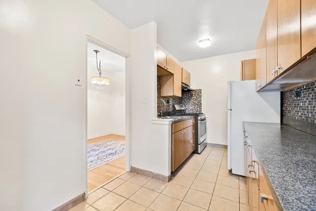 a kitchen with granite countertop a refrigerator and a stove