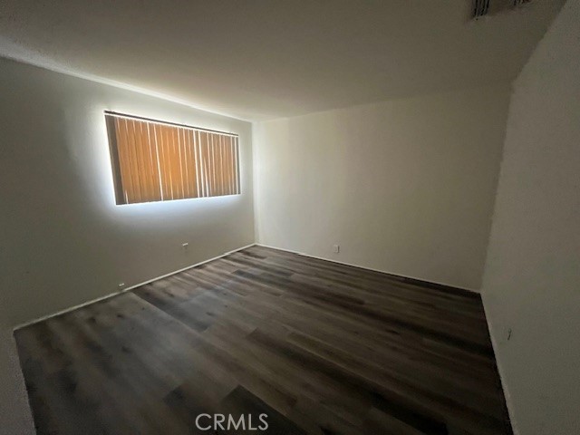 73740 Santa Rosa Way, Unit 5 Palm Desert, CA 92260 - Photo 16 of 20 an empty room with wooden floor and windows
