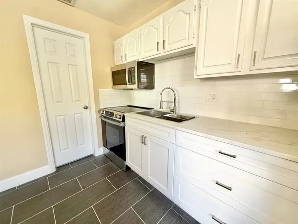 a kitchen with appliances cabinets and a sink