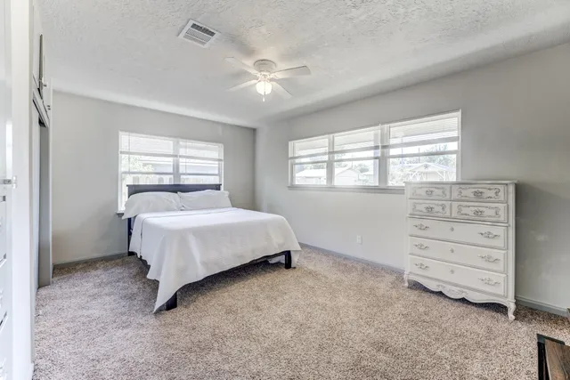 a bedroom with a bed a dresser and a large mirror