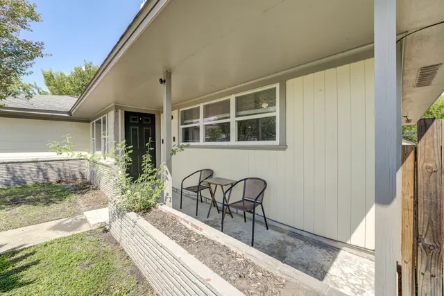 a backyard of a house with table and chairs