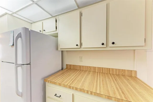 a view of a kitchen with white cabinets and wooden floor