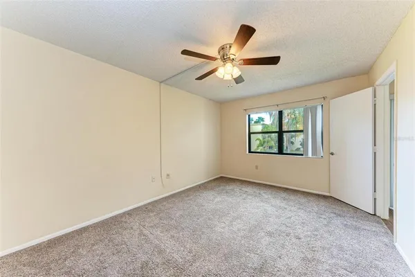an empty room with windows and fan