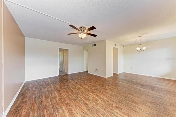 a view of a big room with wooden floor and a ceiling fan