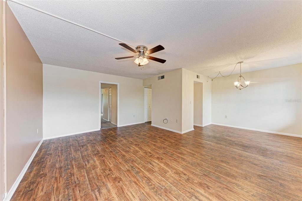 305 30th Avenue West, Unit A210 Bradenton, FL 34205 - Photo 6 of 33 a view of a big room with wooden floor and a ceiling fan