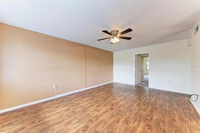 a view of an empty room with wooden floor