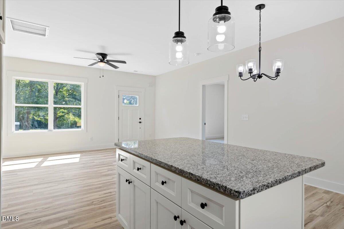79 Theresia Lane Roxboro, NC 27574 - Photo 16 of 31 a kitchen with kitchen island a counter space a ceiling fan and window