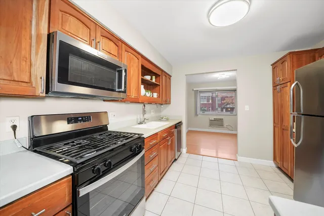 a kitchen with stainless steel appliances granite countertop a stove a refrigerator and a microwave
