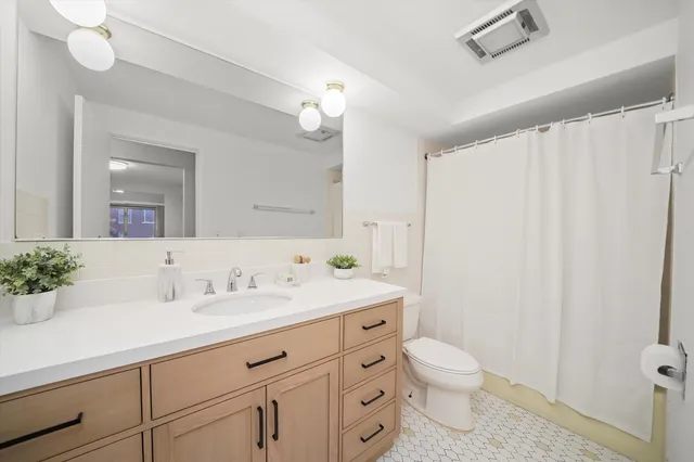 a bathroom with a toilet a sink and a mirror