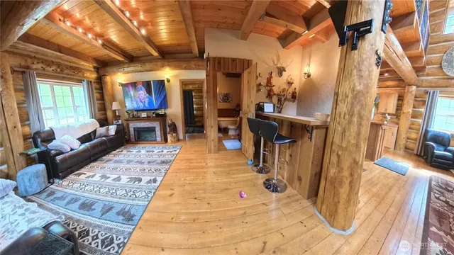 a hallway with a couch and a dining table with wooden floor