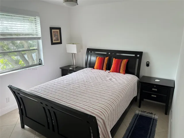 a bedroom with a bed and a dresser next to a window