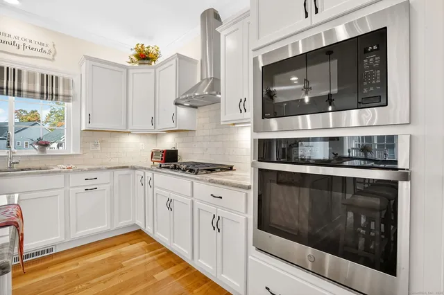 a kitchen with stainless steel appliances granite countertop a stove a microwave and cabinets