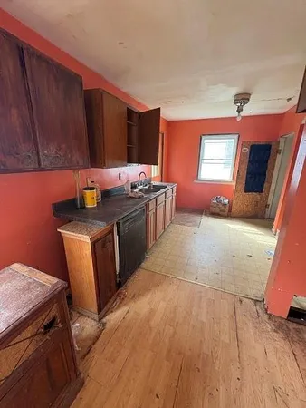 a kitchen with sink a microwave and cabinets