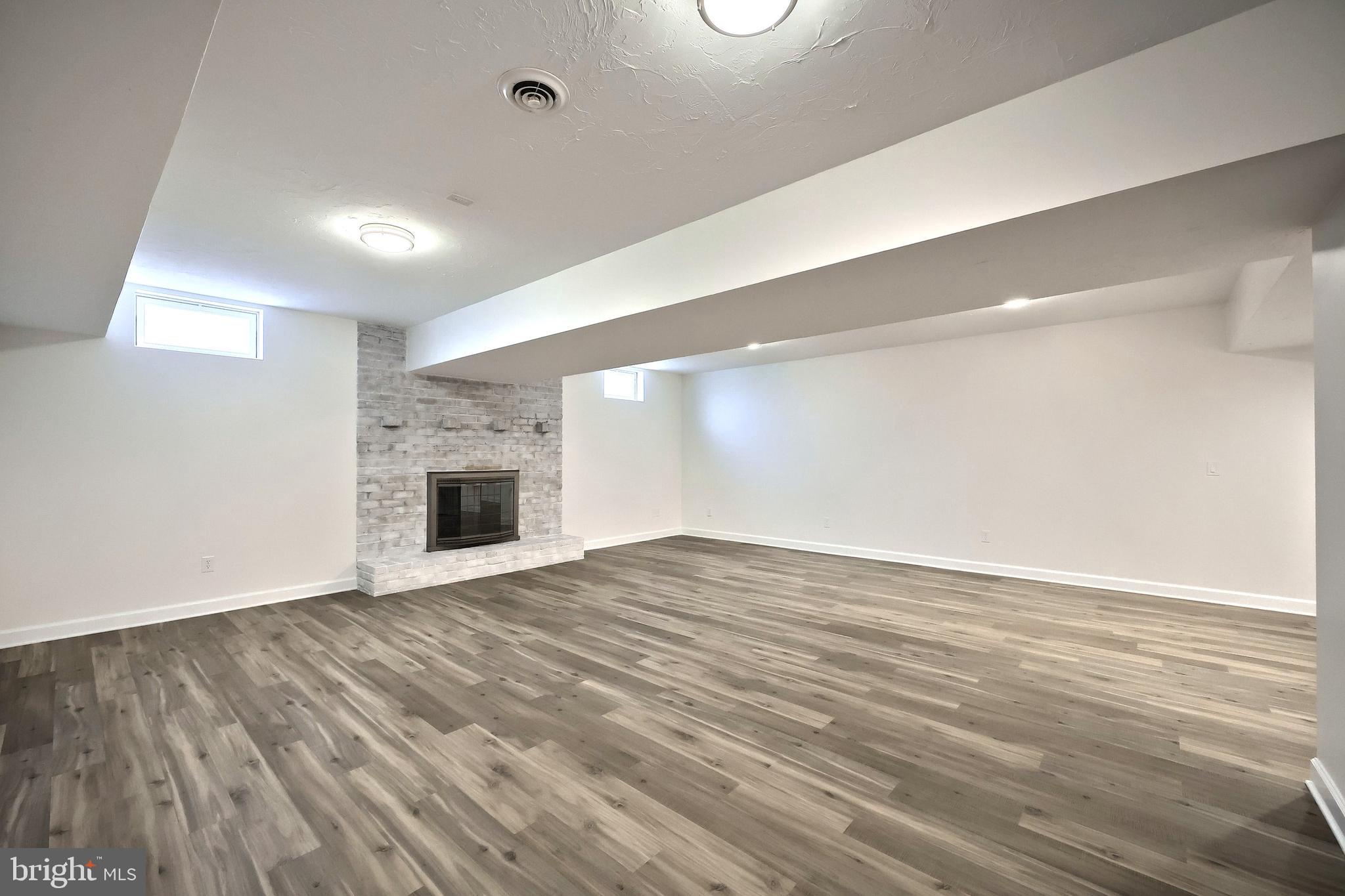 90 Vida Lane Dover, PA 17315 - Photo 27 of 59 an empty room with wooden floor and fireplace