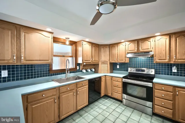 a kitchen with stainless steel appliances granite countertop a refrigerator a sink a stove and a refrigerator