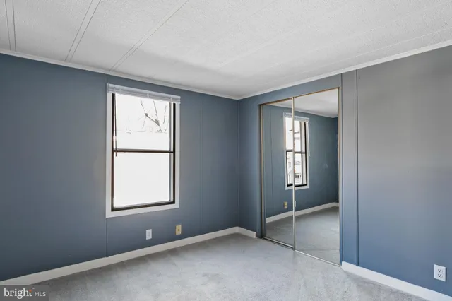 an empty room with windows and closet