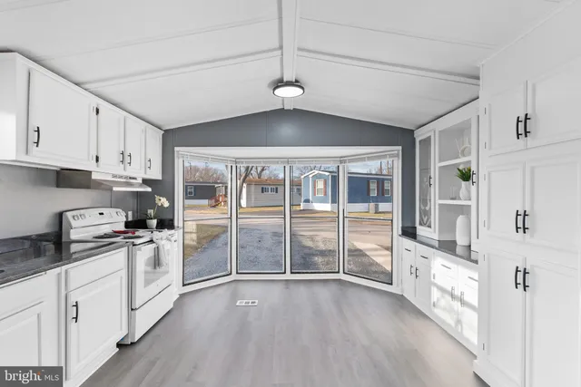 a kitchen with stainless steel appliances a stove a sink and white cabinets