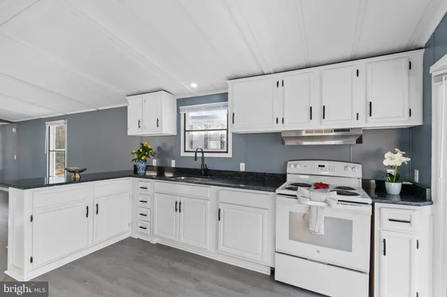 a kitchen with granite countertop white cabinets and white appliances