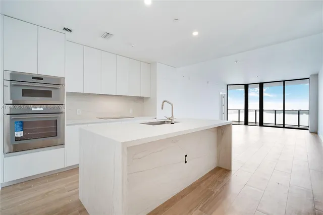 a kitchen with a sink and wooden floor