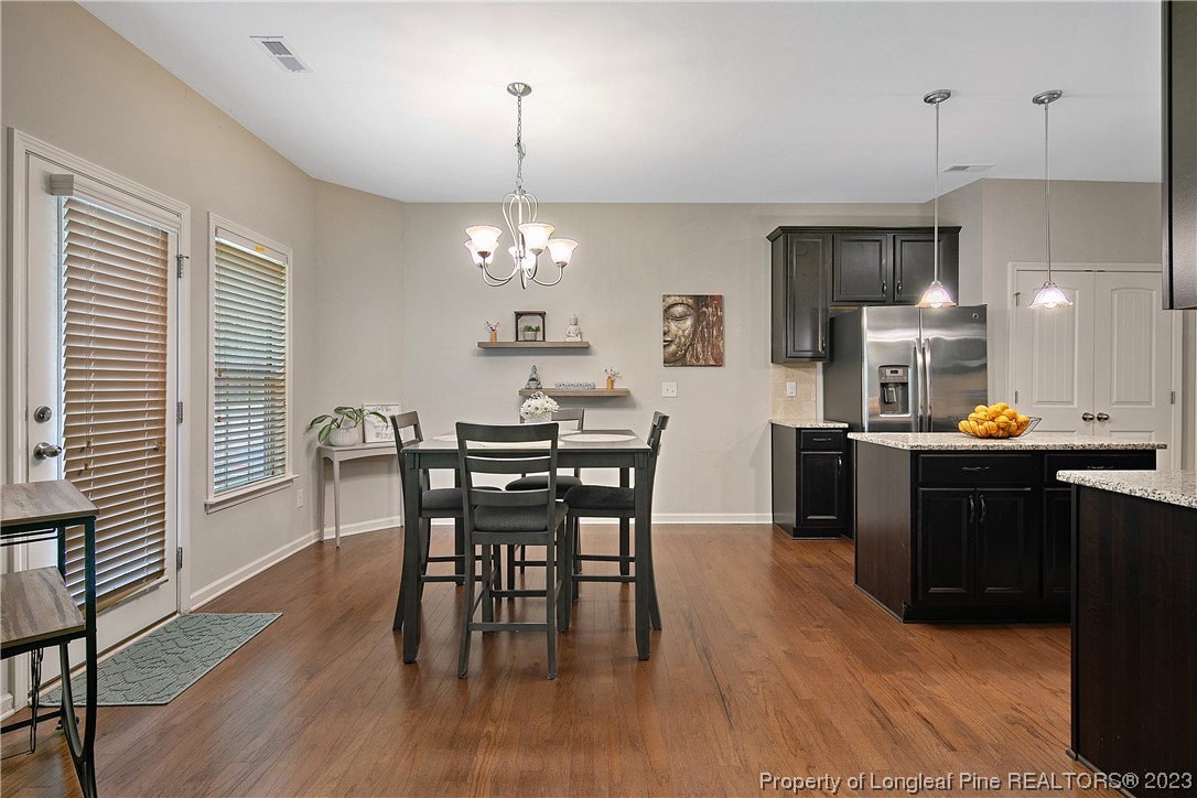 233 Blue Bay Lane Cameron, NC 28326 - Photo 15 of 50 a kitchen with stainless steel appliances a dining table chairs and wooden floor