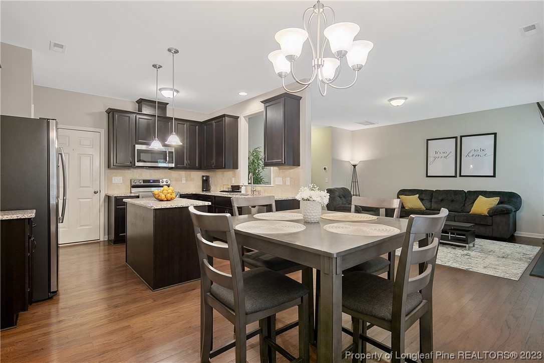 233 Blue Bay Lane Cameron, NC 28326 - Photo 19 of 50 a kitchen with stainless steel appliances granite countertop a refrigerator a stove a sink a dining table and chairs