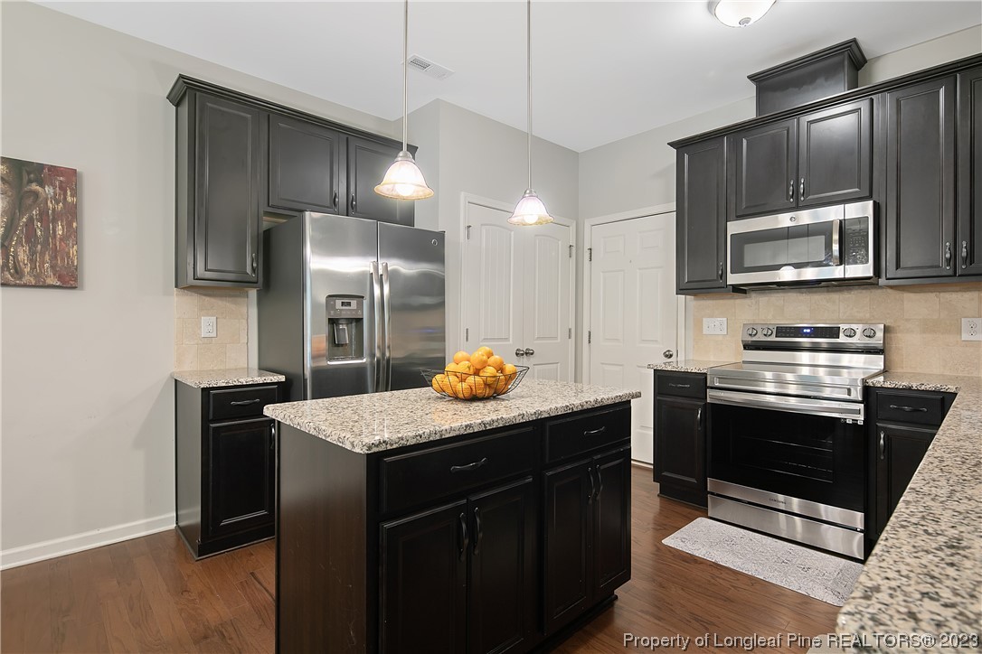 233 Blue Bay Lane Cameron, NC 28326 - Photo 26 of 50 a kitchen with stainless steel appliances kitchen island granite countertop a stove a refrigerator and a microwave