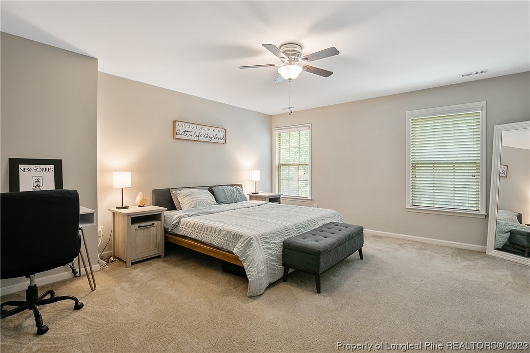 233 Blue Bay Lane Cameron, NC 28326 - Photo 28 of 50 a spacious bedroom with a bed and a chandelier
