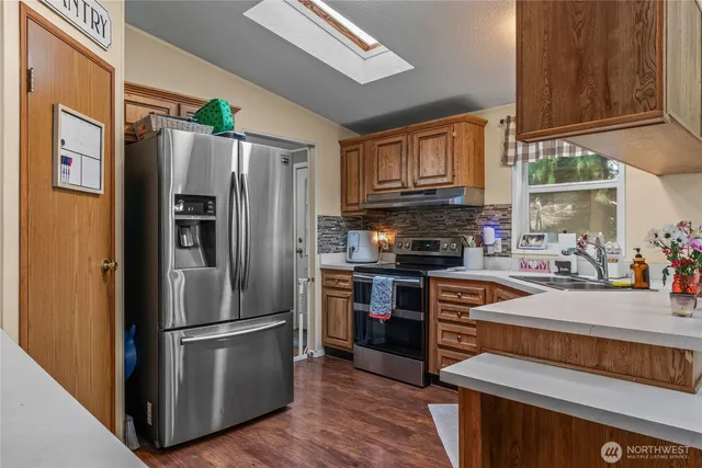 a kitchen with stainless steel appliances granite countertop a refrigerator stove and sink