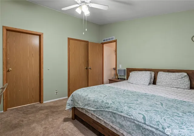 a bedroom with a large bed and a chandelier