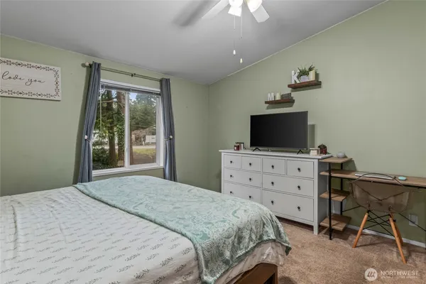 a bedroom with a bed and a flat screen tv