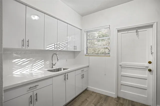 a kitchen with a sink window and cabinets