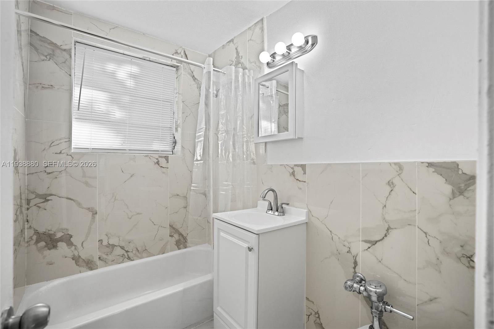 4172 Chase Avenue, Unit 3 Miami Beach, FL 33140 - Photo 17 of 29 a bathroom with a sink a mirror and a bathtub