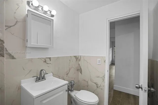 a bathroom with a sink vanity mirror and toilet