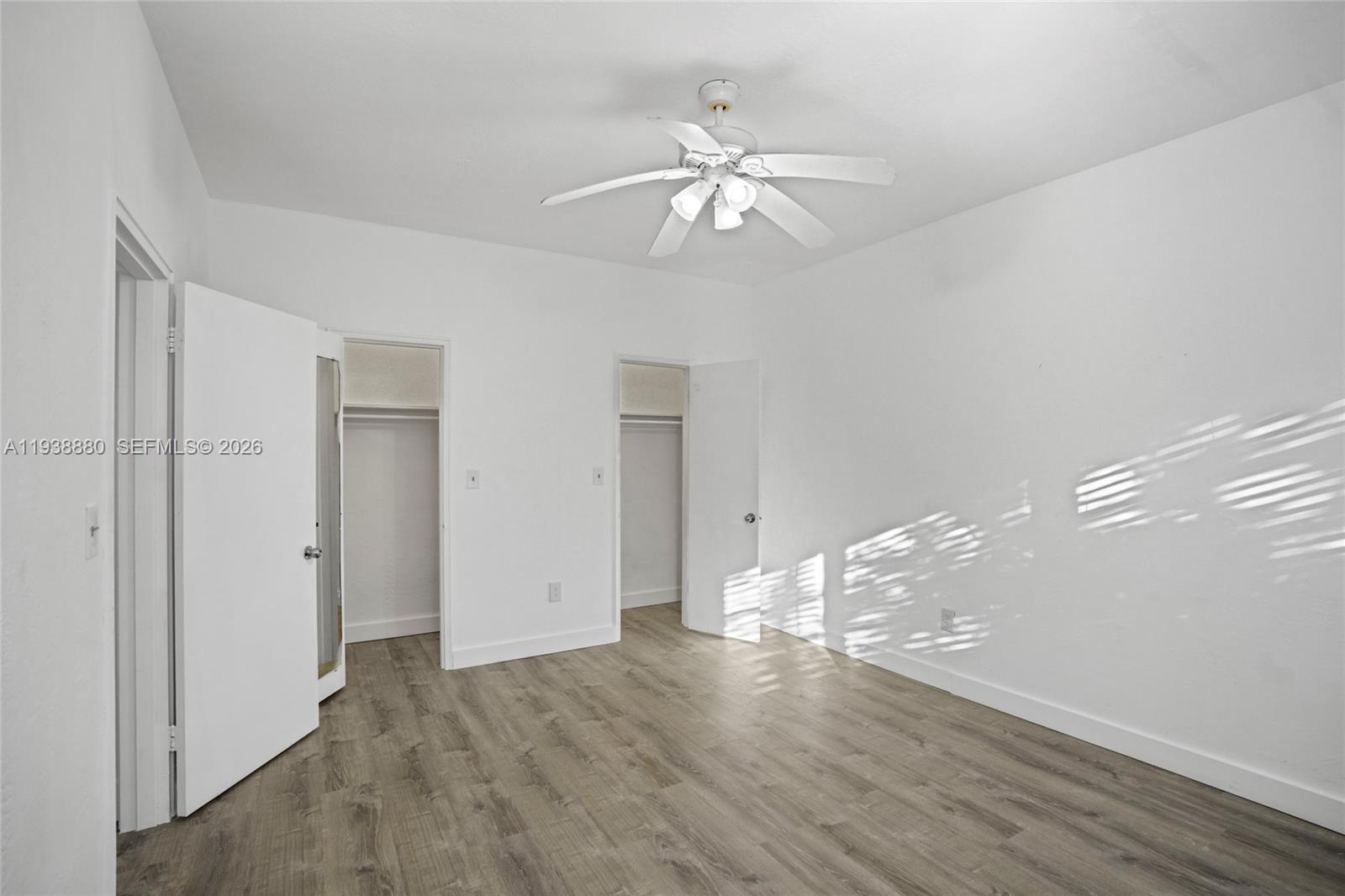 4172 Chase Avenue, Unit 3 Miami Beach, FL 33140 - Photo 20 of 29 a view of an empty room with wooden floor and a ceiling fan