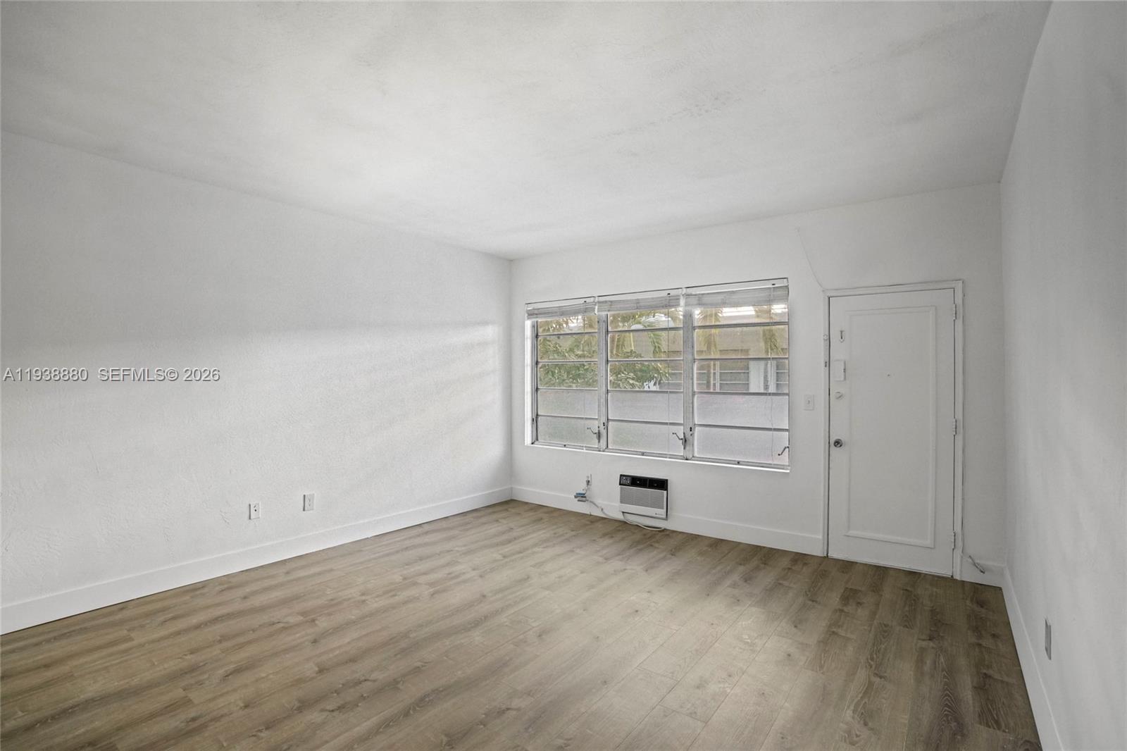 4172 Chase Avenue, Unit 3 Miami Beach, FL 33140 - Photo 5 of 29 an empty room with wooden floor and windows