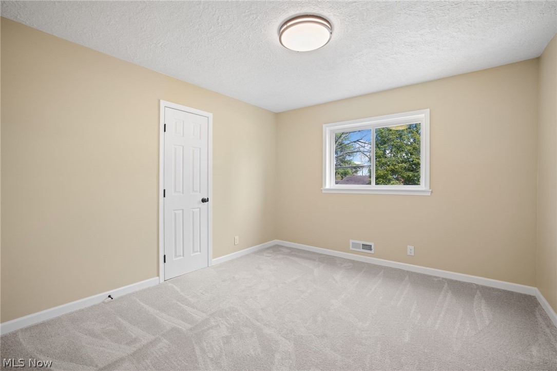 154 Winchester Road Akron, OH 44333 - Photo 19 of 26 Empty room featuring a textured ceiling and light colored carpet