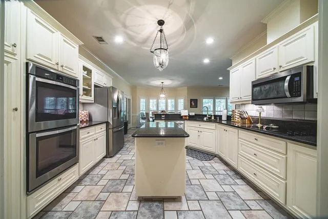 a kitchen with stainless steel appliances granite countertop a sink a stove a microwave and cabinets