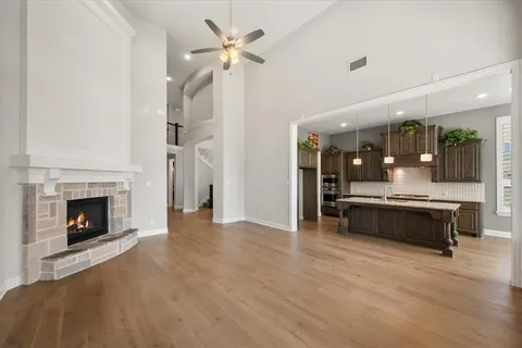 a large living room with a fireplace and a ceiling fan