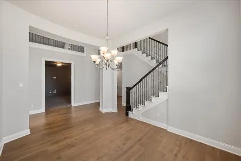 a view of a hallway with wooden floor and staircase